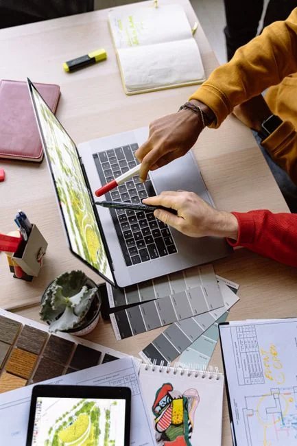 A close-up view of a laptop and tablet resting on a wooden desk, highlighting modern technology.