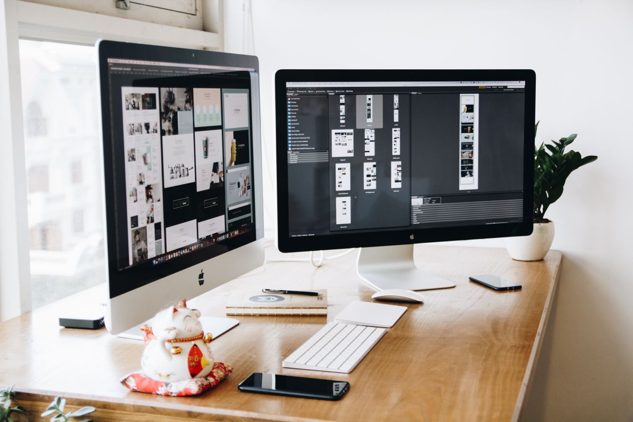 A well-ordered design workspace featuring dual monitors with design software displayed.